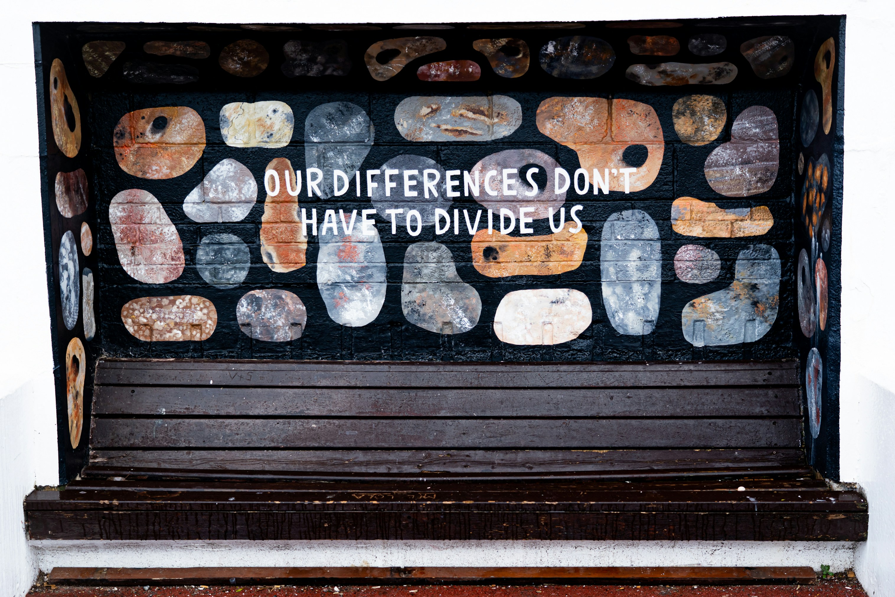 Imagine con una serranda chiusa con la scritta in inglese che dice che ledifferenze non devono dividerci.