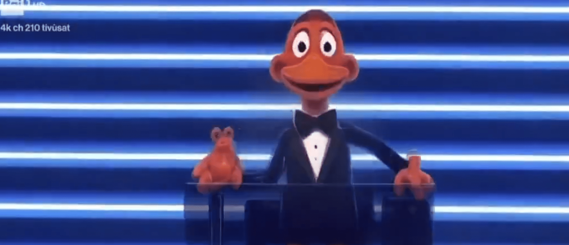 Carlo Comti trasformato in papera dall'IA durante Sanremo 2026.